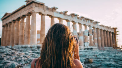 Woman standing in front of ancient building in Athens, Greece