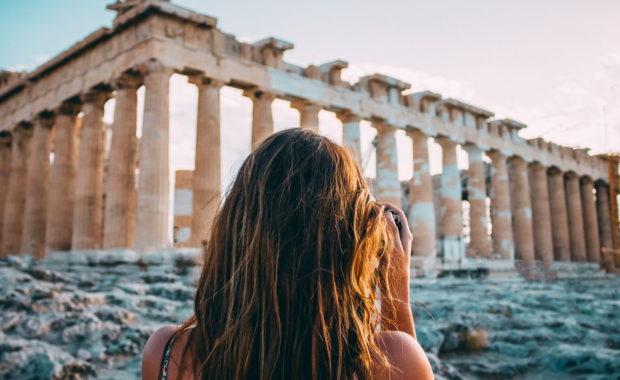 Woman standing in front of ancient building in Athens, Greece